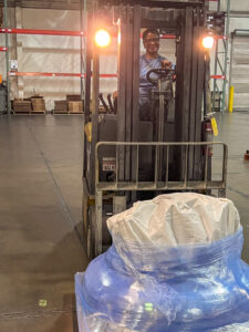 Nicole Smyer, Shipping Clerk at NOVONIX, loads commercial-grade samples of synthetic graphite for outgoing delivery.